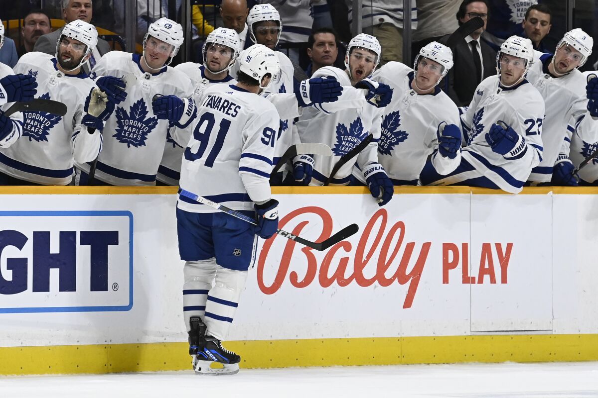 Toronto Maple Leafs center John Tavares (91) is congratulated after scoring against the Nashville Predators during the first period of an NHL hockey game, Sunday, March 26, 2023, in Nashville, Tenn. (AP Photo/Mark Zaleski)