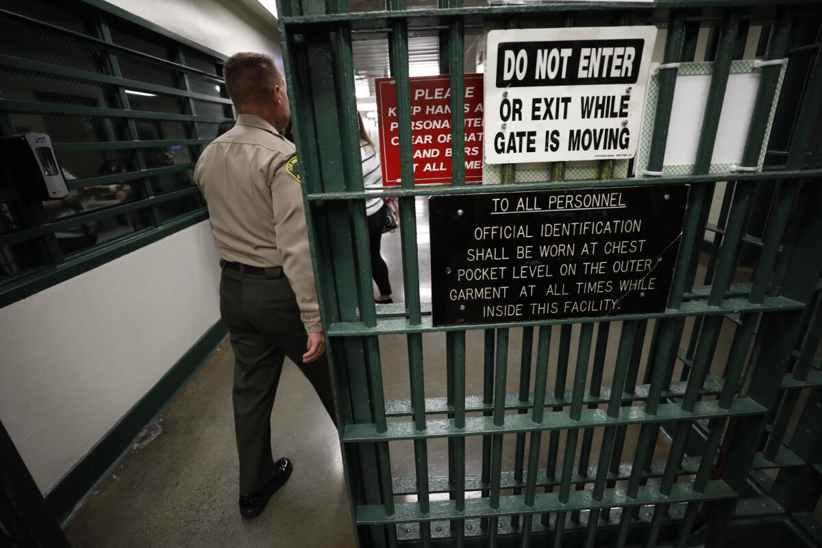 An officer walks through a  gate inside a jail