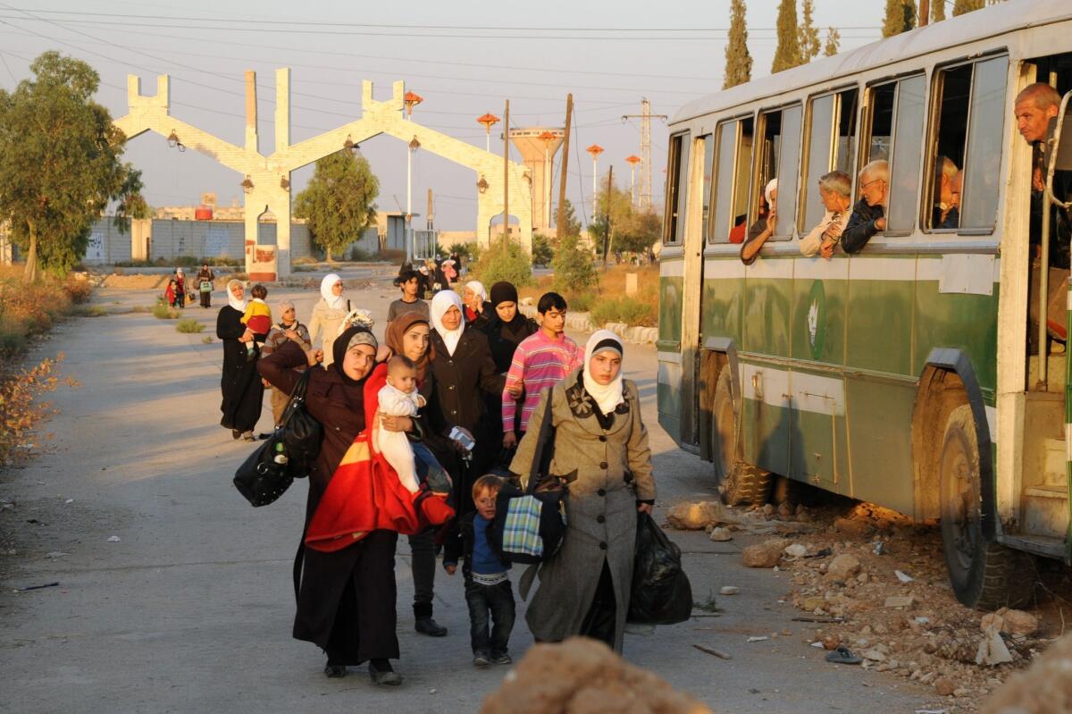 A picture released by the official Syrian Arab News Agency on Saturday shows Syrian women and children arriving to be evacuated by Syria's Red Crescent from a Damascus suburb that has been under siege by the Syrian army for months.