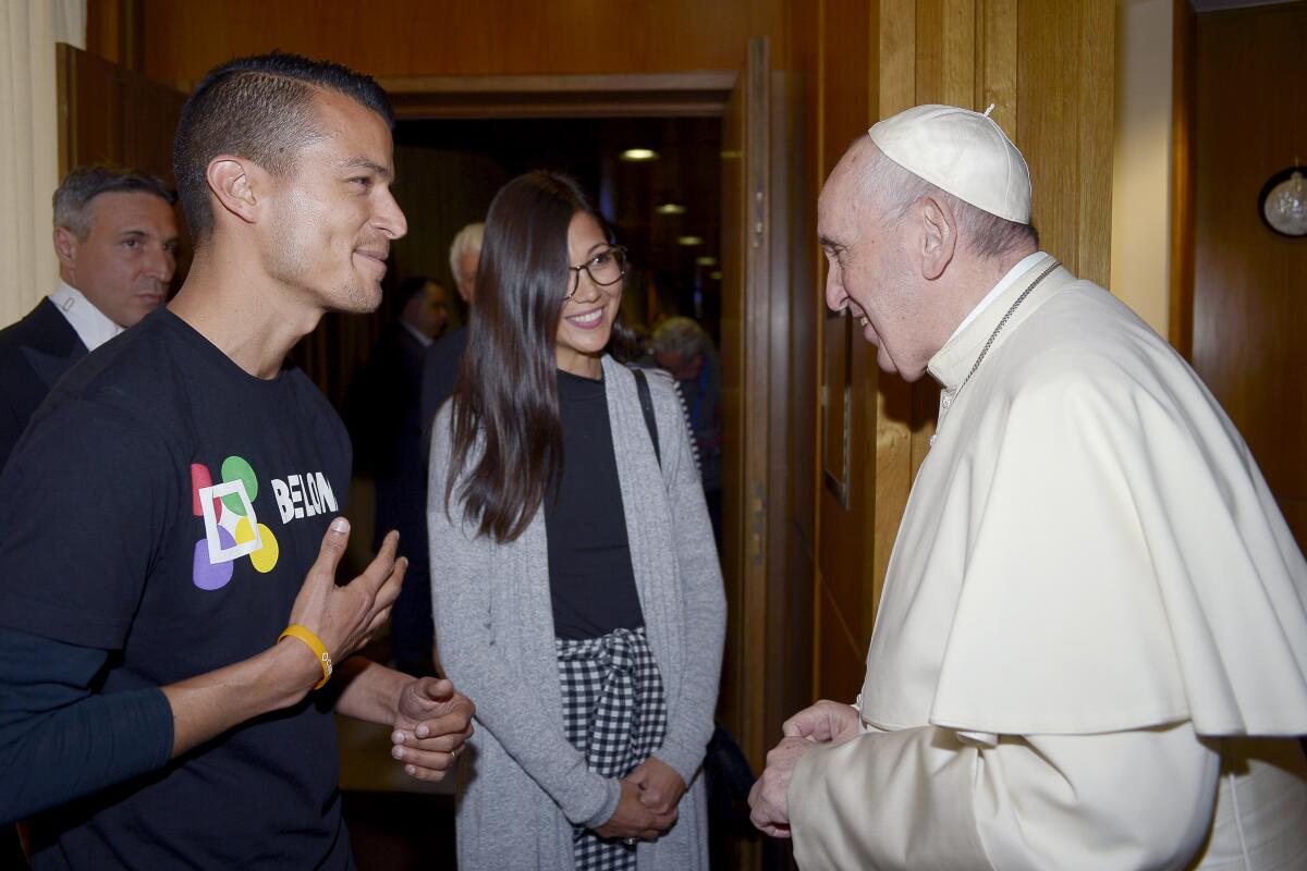 A young man and woman talking with Pope Francis