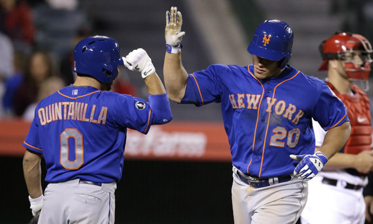 New York Mets' Anthony Recker, right, celebrates with teammate Omar Quintanilla after hitting a solo home run in the 13th inning of the Angels' 7-6 loss Saturday night.