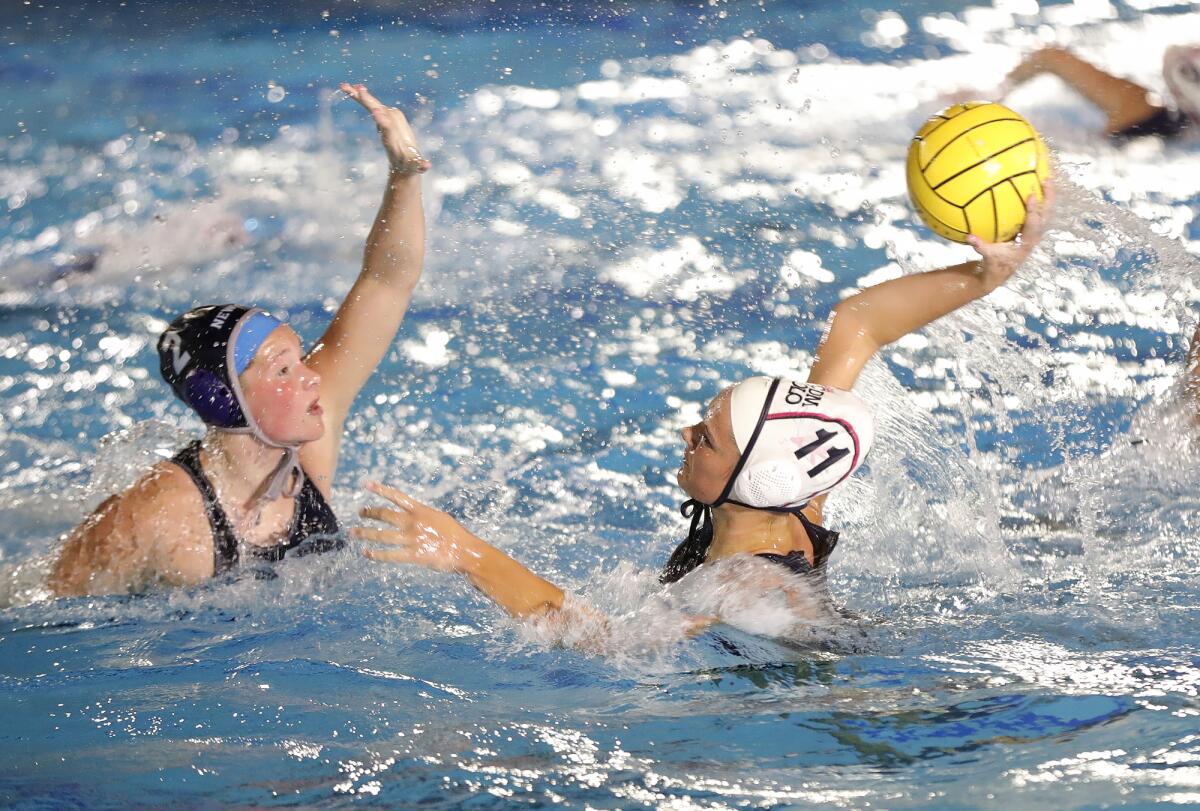 CdM's Reagan Weir (11) shoots and scores during the annual Battle of the Bay girls' water polo match on Thursday.