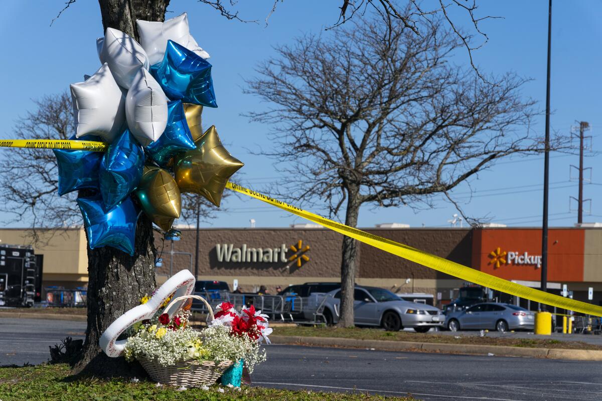 Flowers and balloons placed near the scene of a mass shooting at a Walmart.