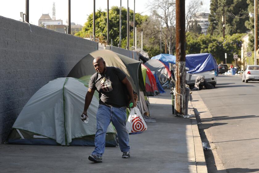 LOS ANGELES, CA - NOVEMBER 24: Ruben A. Colon, 37, who lives in a tent on Carlos Avenue in Hollywood calls himself a "Urban Pilgrim" as he and his homeless neighbors enjoy the quiet location. Covid-19 restrictions has created challenges for homeless people seeking indoor spaces where they used to find respite. They can no longer go into libraries or cafes to sit inside and charge phones and get on the Internet and stay warm during the day. Hollywood on Tuesday, Nov. 24, 2020 in Los Angeles, CA. (Al Seib / Los Angeles Times