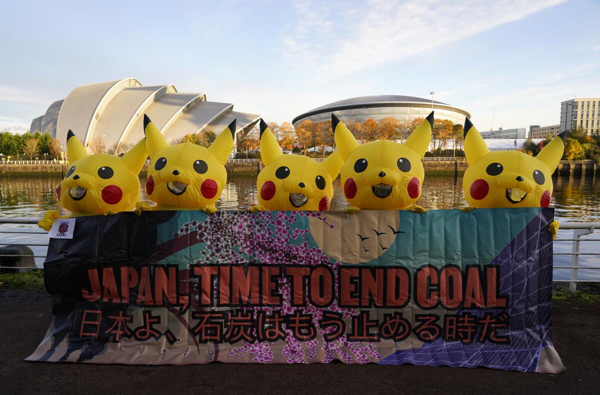 Costumed activists with banner demanding end to coal use