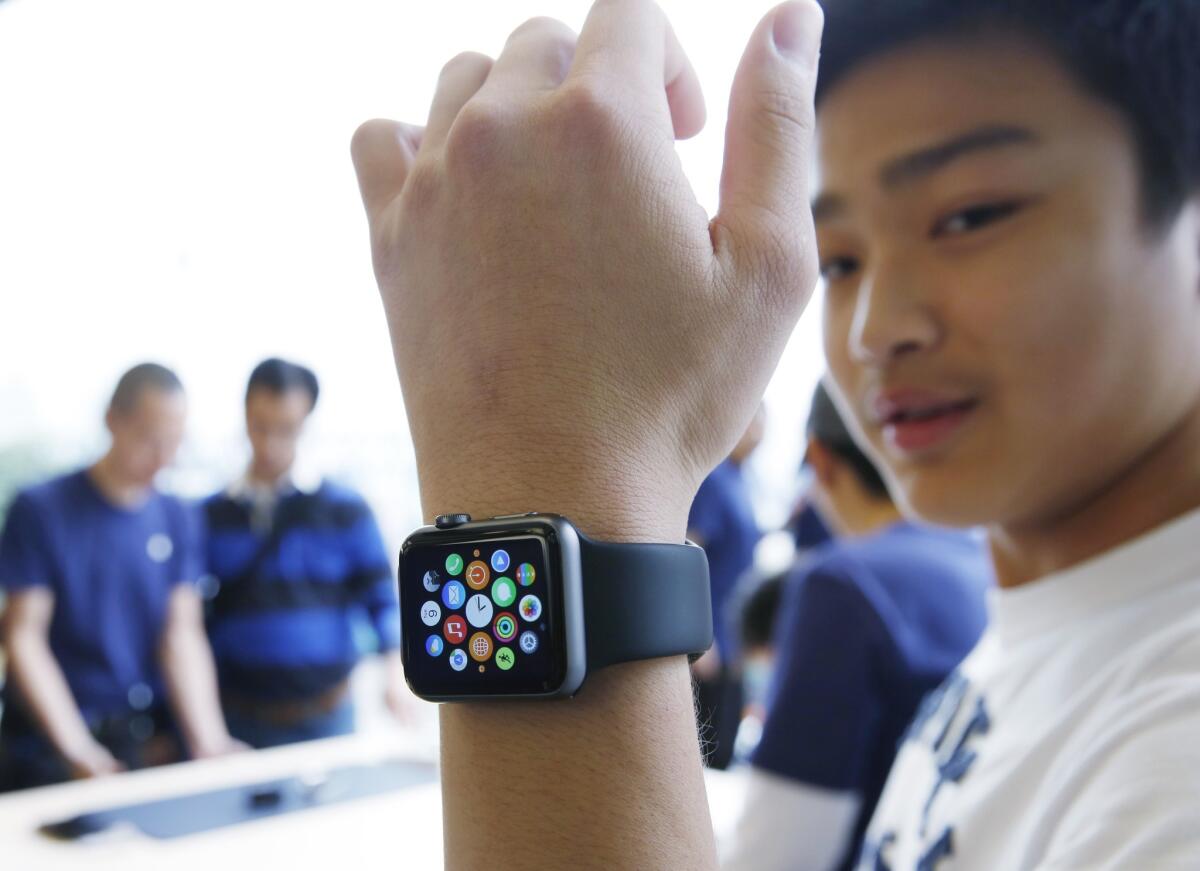 A customer tries on an Apple Watch at an Apple Store in Hong Kong on the first day the new device was available.