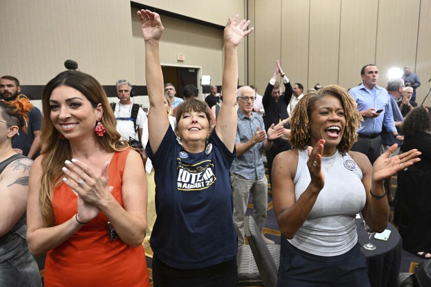 Calley Malloy, left, of Shawnee, Kan.; Cassie Woolworth, of Olathe, Kan.; and Dawn Rattan, right, of Shawnee, Kan., applaud during a primary watch party Tuesday, Aug. 2, 2022, in Overland Park, Kan. Kansas voters rejected a ballot measure in a conservative state with deep ties to the anti-abortion movement that would have allowed the Republican-controlled Legislature to tighten restrictions or ban abortion outright.(Tammy Ljungblad AP)/The Kansas City Star via AP)