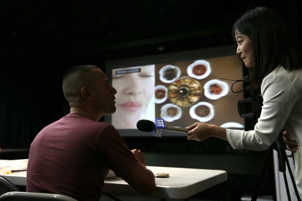 LAPD Officer Antonio Manzano is interviewed by SBS International reporter Jae Rin Lee during a break in a daylong seminar on Korean culture at the Korean Cultural Center.