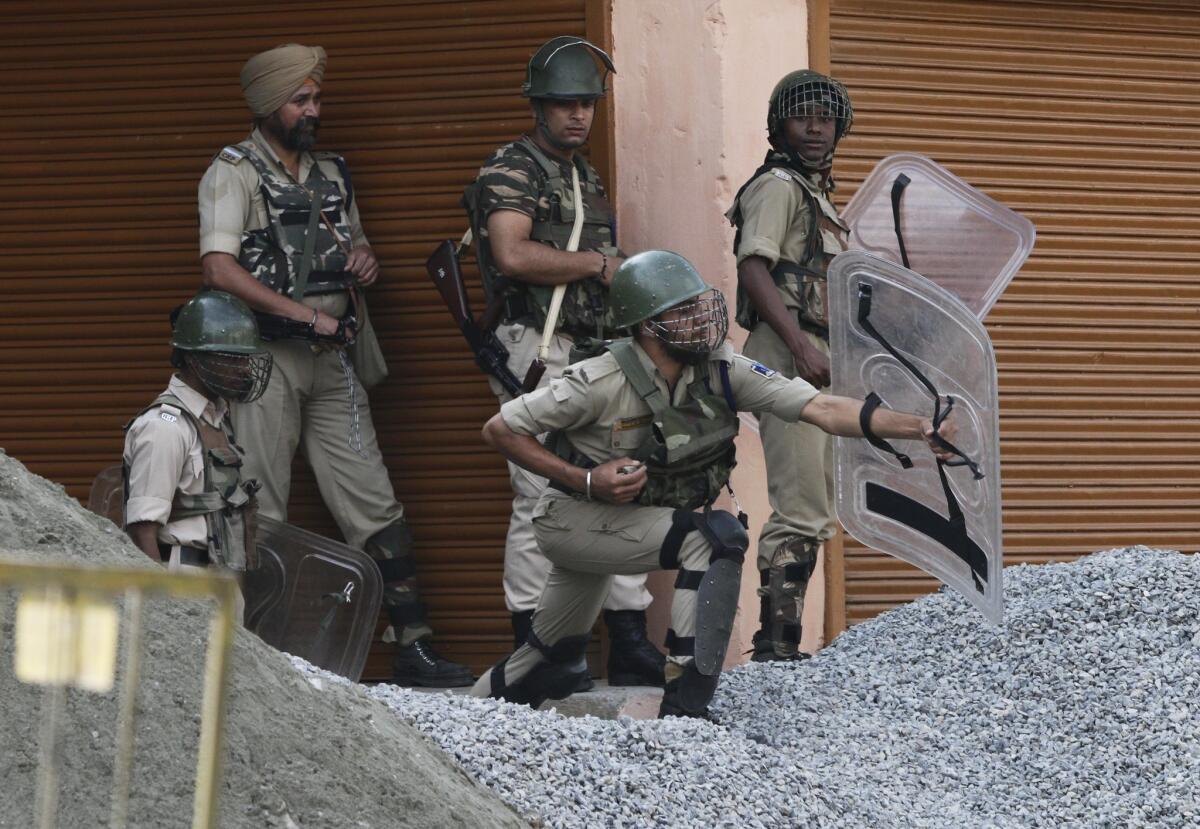 Indian paramilitary soldiers shield themselves as Kashmiris throw stones at them during a protest in the Indian-controlled portion of Kashmir on Friday. Kashmir, which is divided between India and Pakistan, remains a sticking point in efforts to improve relations between the two nations.