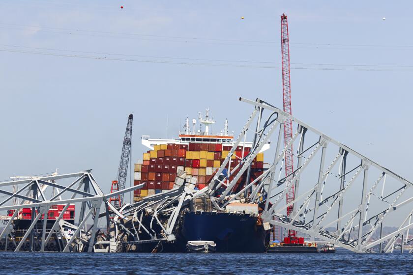 The collapsed Francis Scott Key Bridge lay on top of the container ship Dali, Monday, April 15, 2024, in Baltimore. The FBI confirmed that agents were aboard the Dali conducting court-authorized law enforcement activity. (AP Photo/Julia Nikhinson)