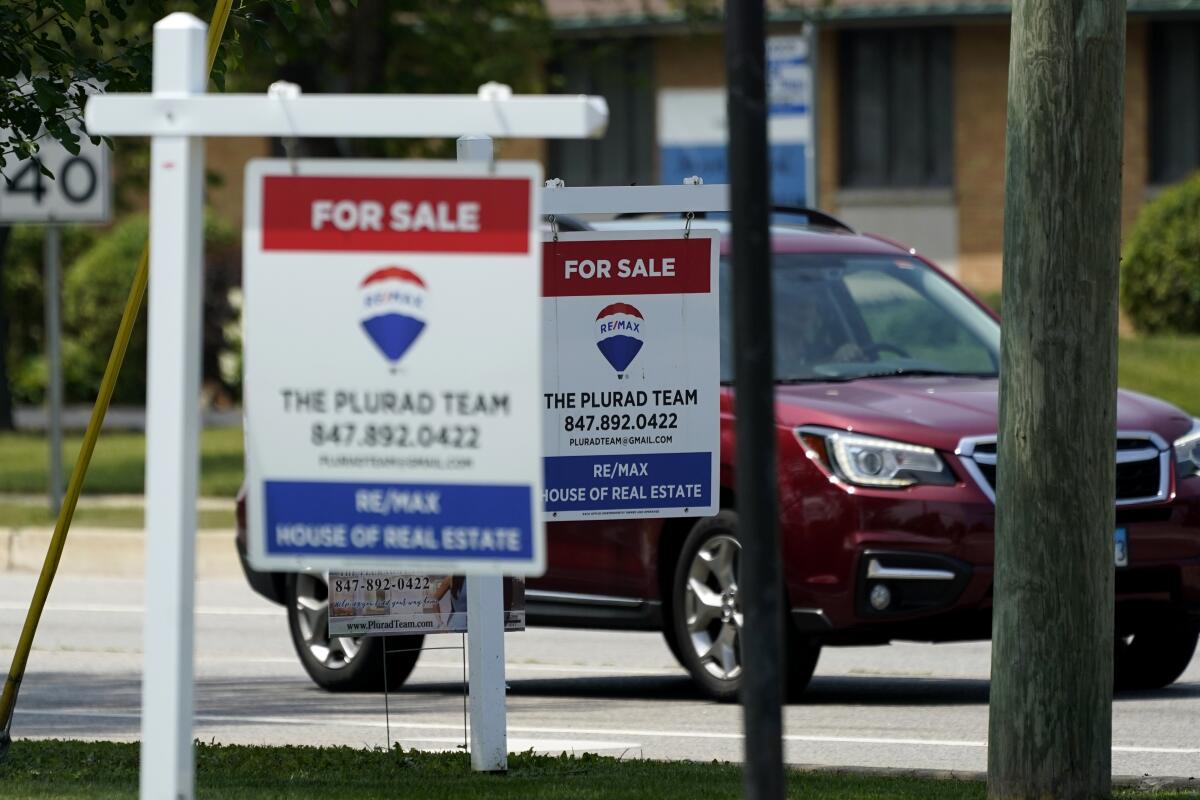 "For Sale" signs are seen outside a home in Glenview, Ill., Tuesday, July 27, 2021. Mortgage rates were flat to lower last week, Aug. 5, with the average for the key 30-year home loan below 3% for the sixth straight week. (AP Photo/Nam Y. Huh)