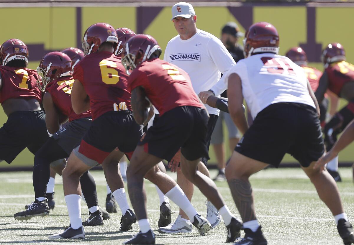 USC head football coach Clay Helton runs players through warm-ups during the opening of training camp at USC on Aug. 2.