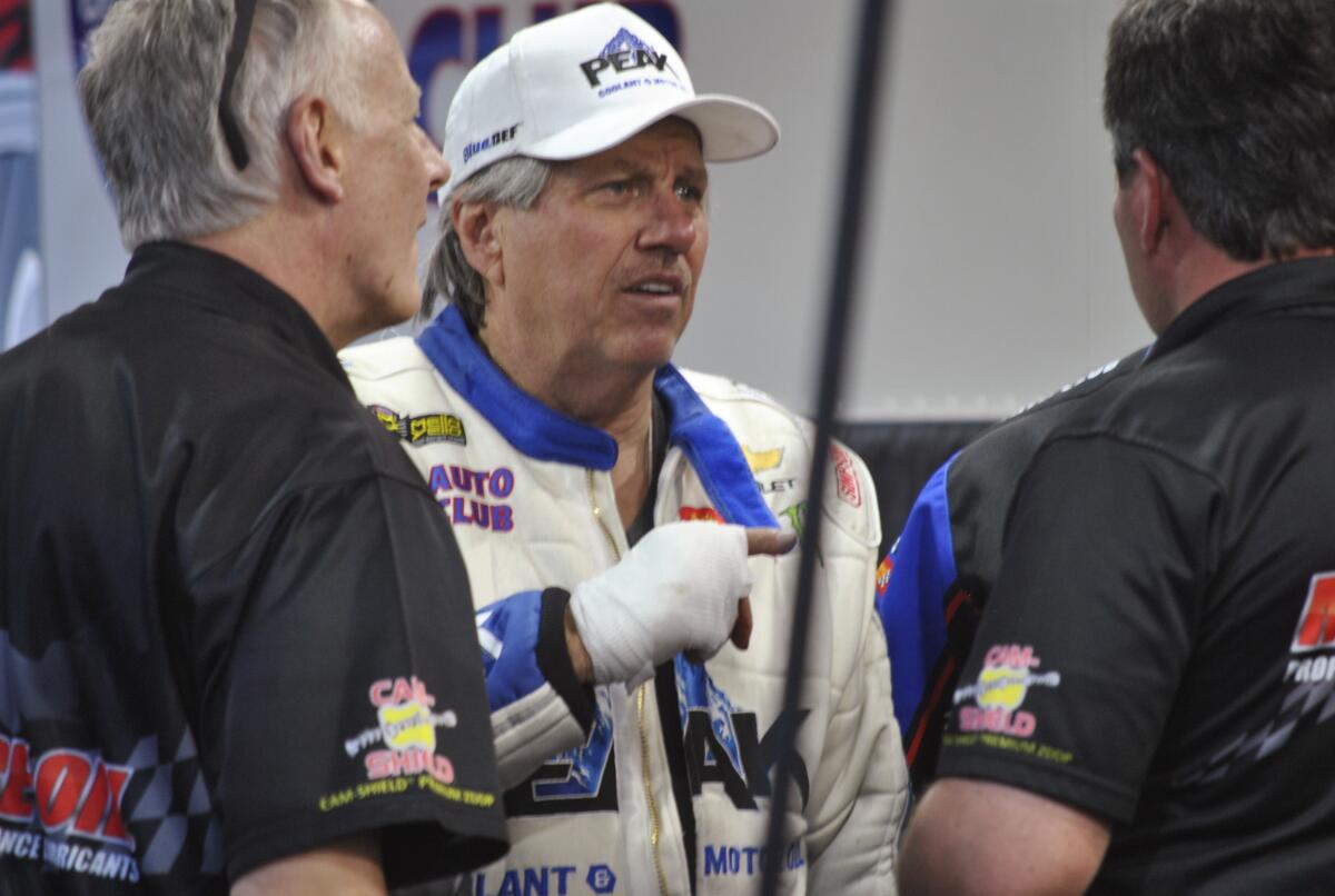 John Force talks to crew members at the NHRA Gatornationals in Gainesville, Fla. in 2018.