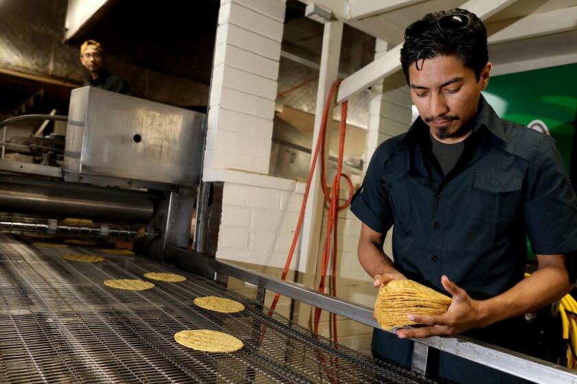 LOS ANGELES, CALIF. -- THURSDAY, MAY 23, 2019: Ommar Ahmed Hernandez, 33, co-owner, counts yellow corn tortillas at Kernal of Truth makers of blue and yellow organic tortillas in Los Angeles, Calif., on May 23, 2019. (Gary Coronado / Los Angeles Times)
