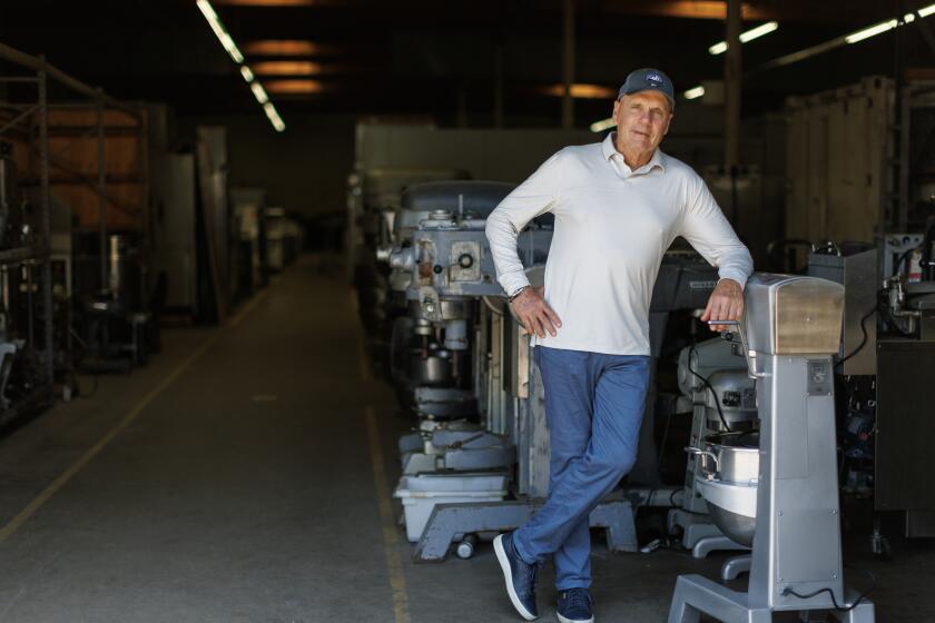 Fred Bush stands in his warehouse which is filled with leftover and reconditioned restaurant equipment.