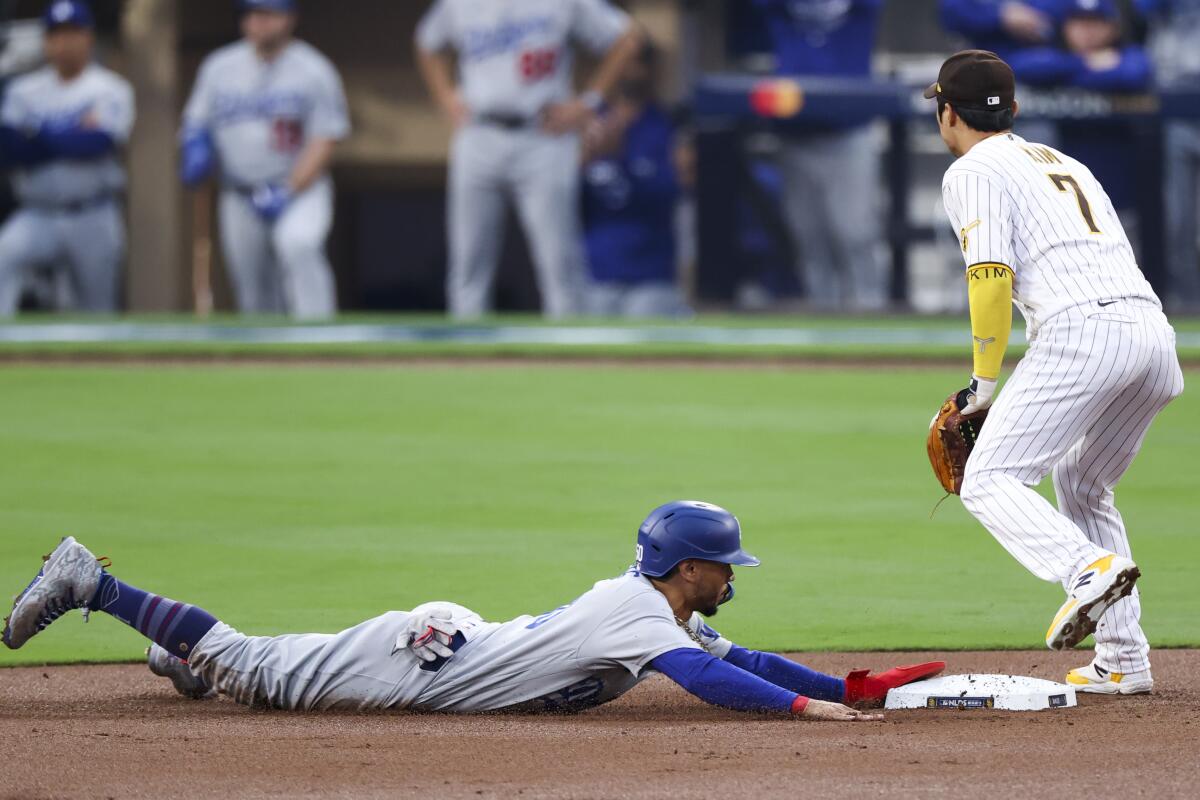 The Dodgers' Mookie Betts slides into second base in the first inning. Padres shortstop Ha-Seong Kim is at right.