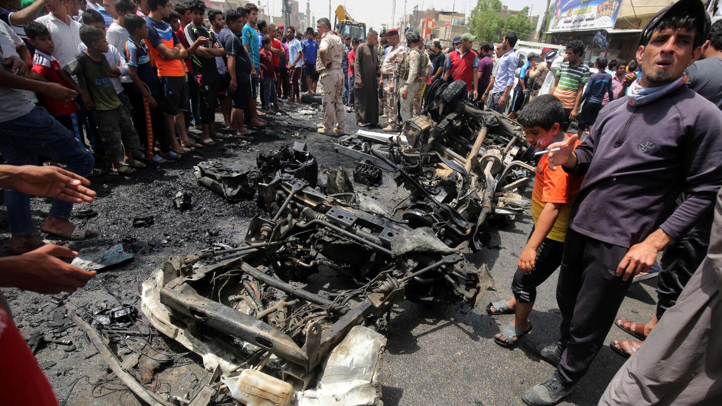 Iraqis look at the damage from a car bomb attack May 11 in Sadr City, a Shiite area north of the capital, Baghdad.