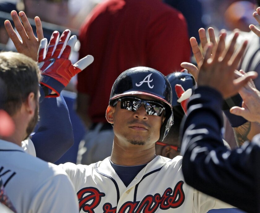 Atlanta Braves' Christian Bethancourt celebrates with teammates in the dugout after scoring a run during the eighth inning of a baseball game against the New York Mets, Sunday, Sept. 13, 2015, in Atlanta. (AP Photo/Butch Dill)