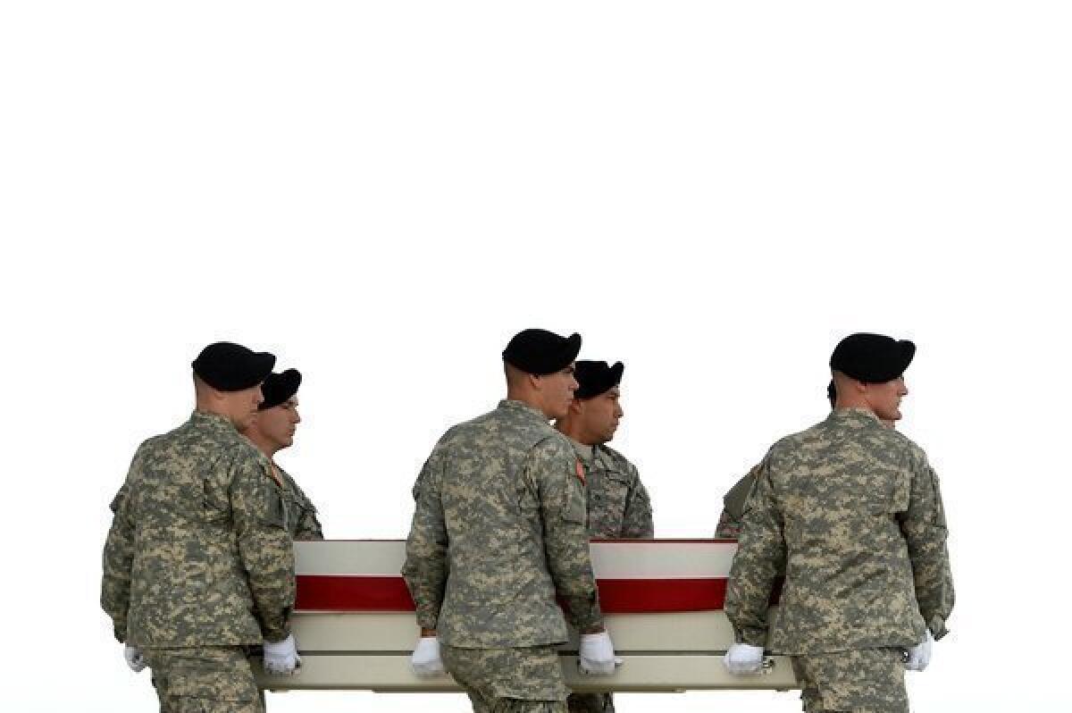 U.S. Army soldiers carry the flag-draped transfer case containing the remains of U.S. Army Pfc. Cody J. Patterson at Dover Air Force Base in Delaware.