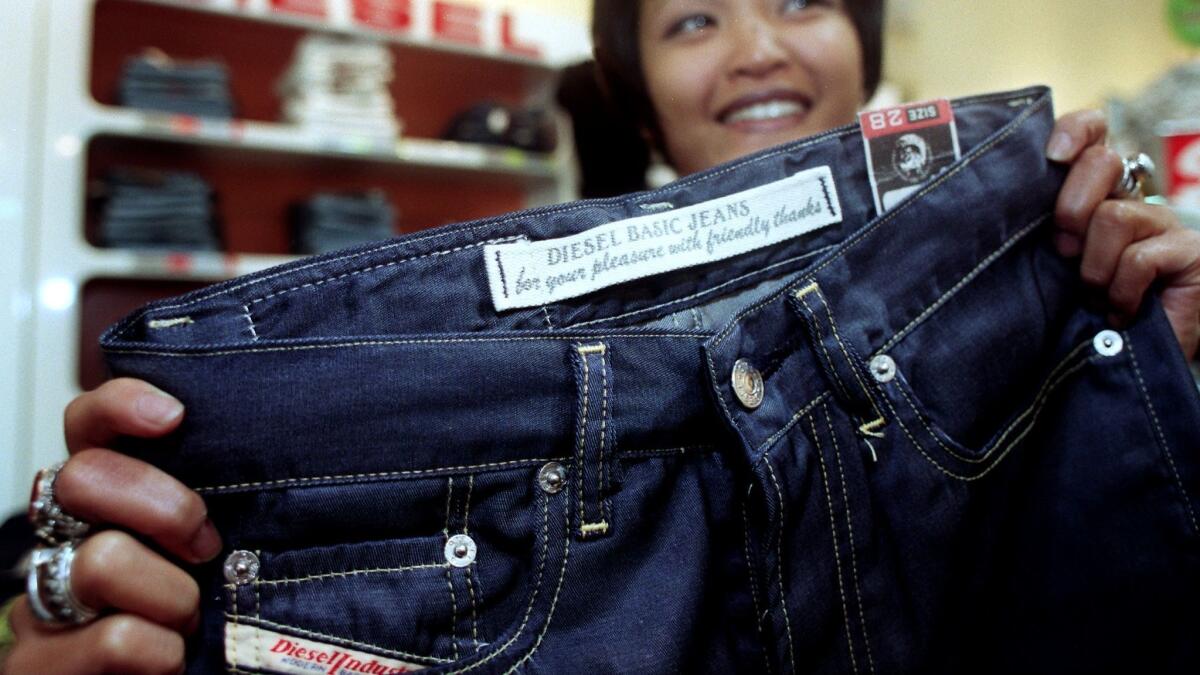 A sales clerk shows off a pair of Diesel jeans in 1997.