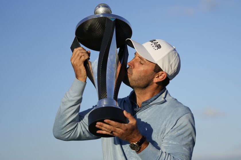Charles Schwartzel of South Africa kisses the trophy as he poses for the media after he won.