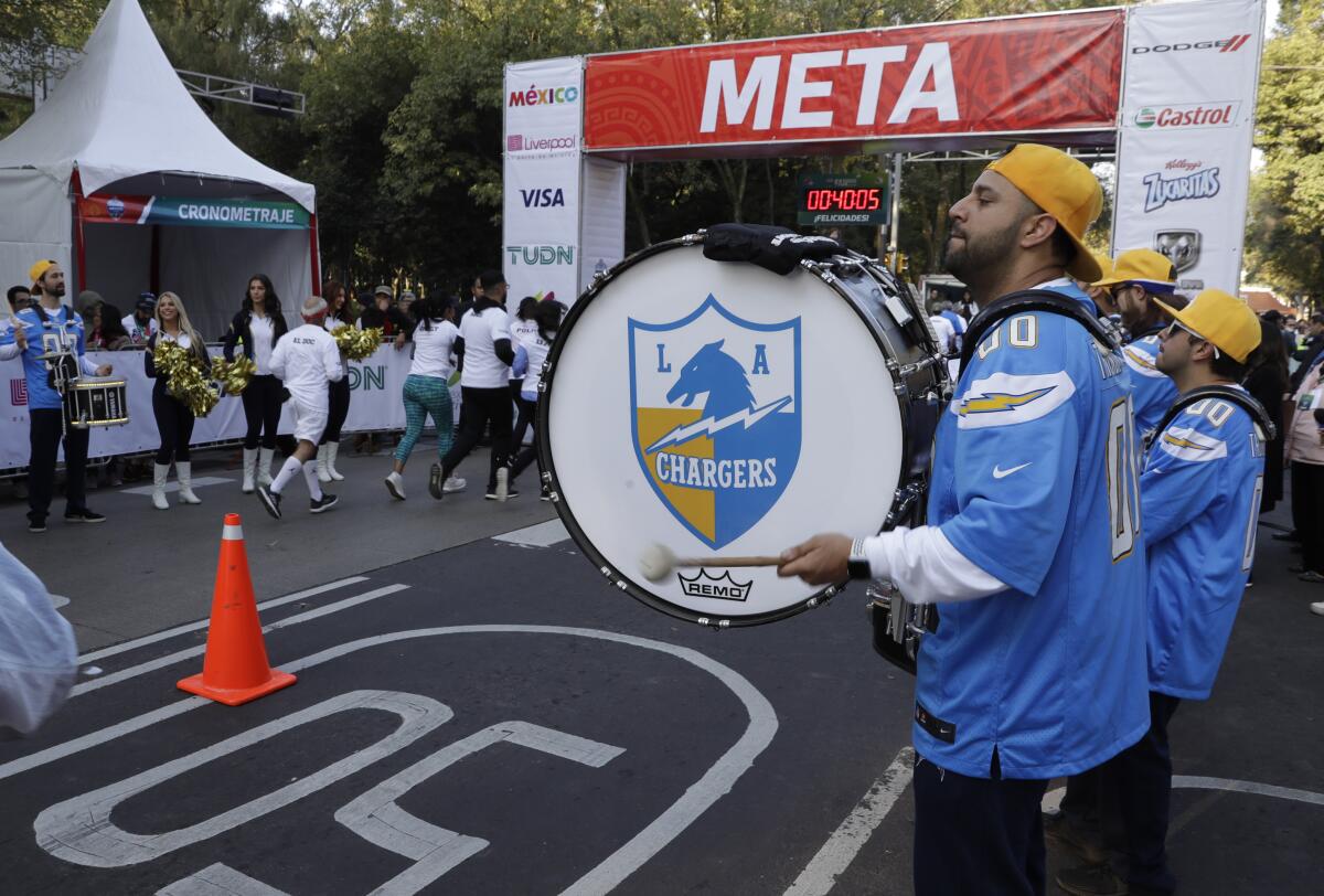 The Chargers' Thunderbolt Drumline and Lightning Crew greet runners at the finish line for a fan race in Mexico City on Nov. 17, 2019.