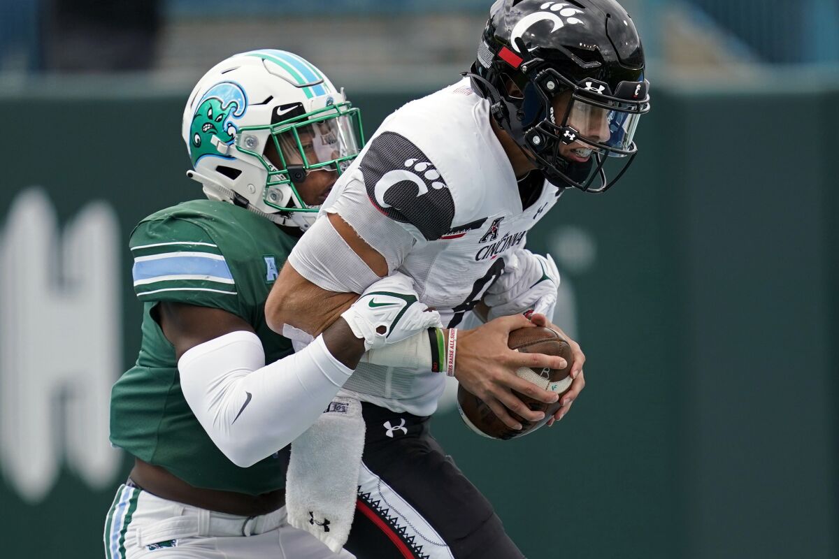 Tulane linebacker Marvin Moody (0) sacks Cincinnati quarterback Desmond Ridder (9) for a safety during the first half of an NCAA college football game in New Orleans, Saturday, Oct. 30, 2021. (AP Photo/Gerald Herbert)