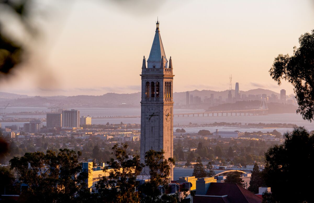 A UC Berkeley tower with San Francisco skyline on the horizon. 