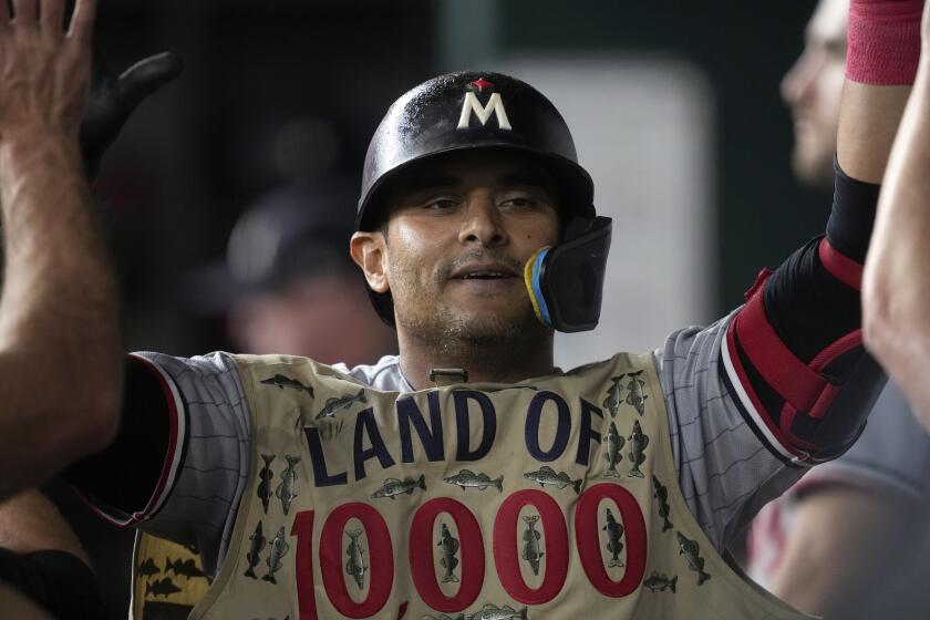 Minnesota Twins' Donovan Solano celebrates in the dugout after hitting a home run during a baseball game against the Texas Rangers, Saturday, Sept. 2, 2023, in Arlington, Texas. (AP Photo/Tony Gutierrez)