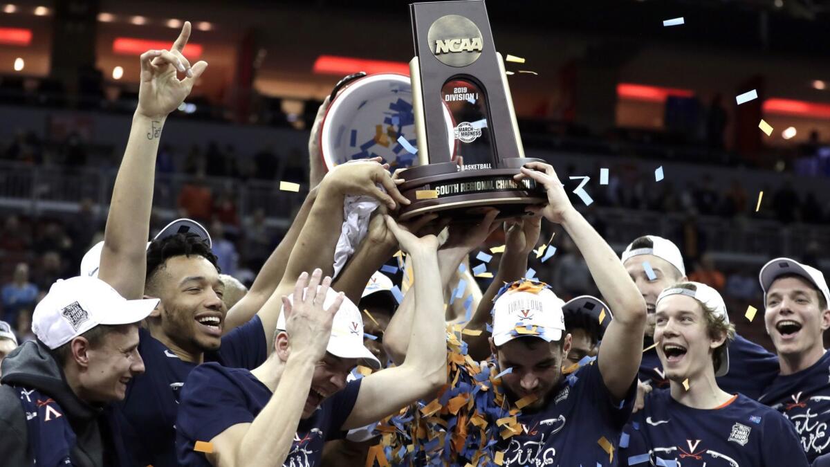 Members of Virginia celebrate after defeating Purdue 80-75 in overtime of the NCAA tournament South Regional final on Saturday in Louisville, Ky.