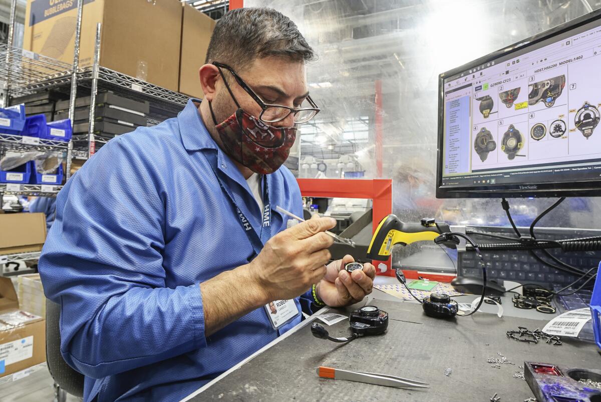 Worker builds wireless headsets at a manufacturer in Carlsbad