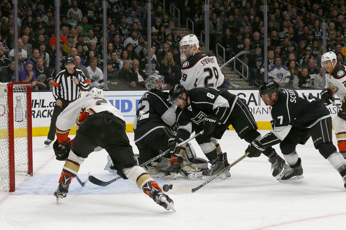 Kings defenseman Drew Doughty (8) knocks the puck away from the goal before Ducks center Mike Santorelli can get to it during the second period.
