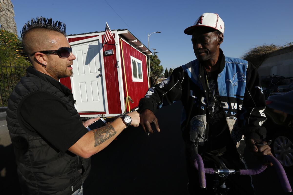Elvis Summers, left, fist bumps Donnell McKinney, 56, to reassure him that he is only taking his tiny home temporarily after the city of Los Angeles began seizing the homes.