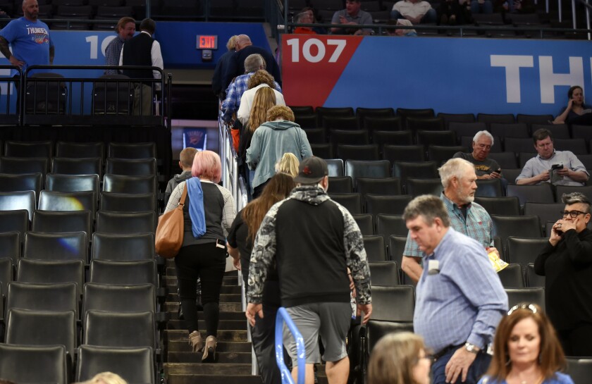 Basketball fans leave Chesapeake Energy Arena after it is announced that an NBA basketball game.