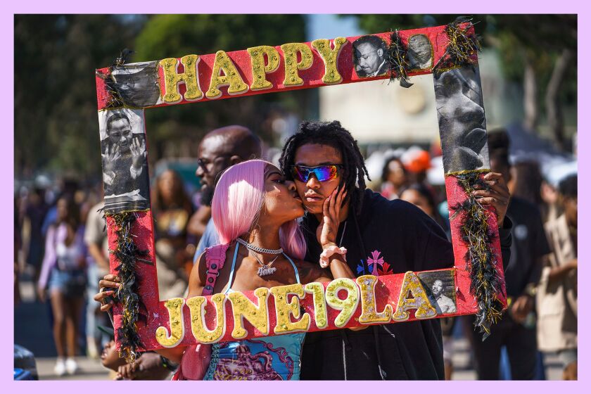 Daisa Chantel kisses Anthony Beltran as they take a picture to celebrate Juneteenth at Leimert Park in Los Angeles on Saturday, June 18, 2022.
