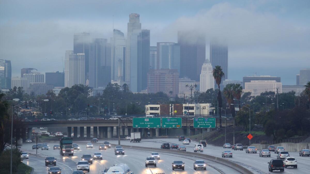 Commuters navigate slick freeways in downtown Los Angeles on Jan. 19 as the first of three storms drenched the Southland.