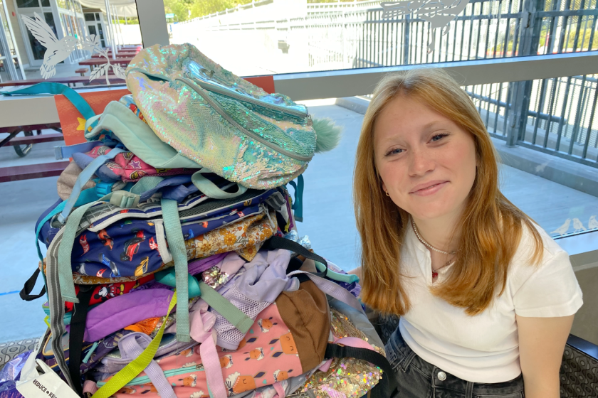 Kalia Roper with some of the donated backpacks.