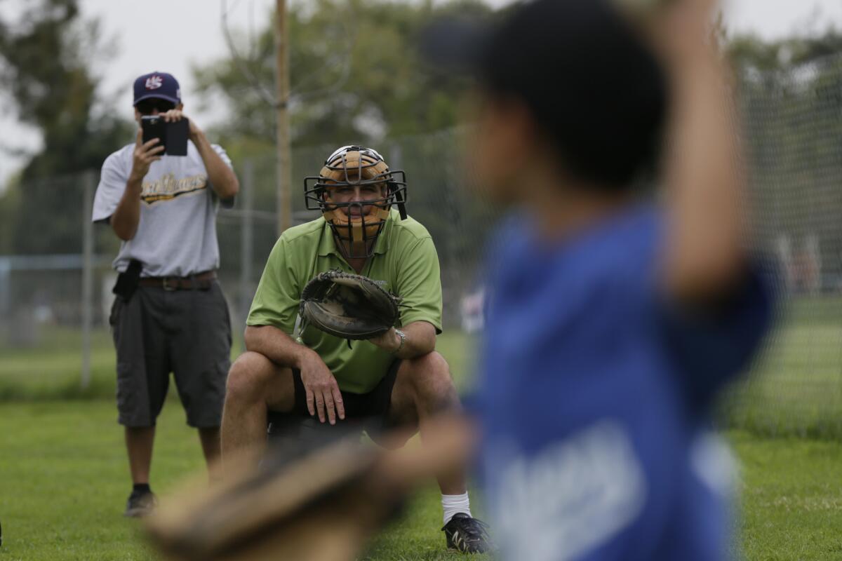 SANTA MONICA, CA, SUNDAY, JULY 21, 2013 - Former Dodgers pitcher Tim Leary holds an instructional session with Dodger Rios, 6, at Clover Park. Robert Rios, Dodger's father, shoots smartphone video as he pitches. (Robert Gauthier / Los Angeles Times).