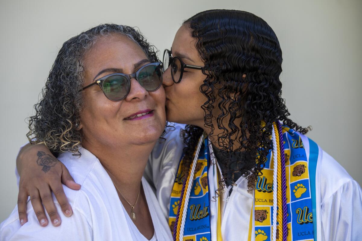 A teenager kisses her mom on the cheek