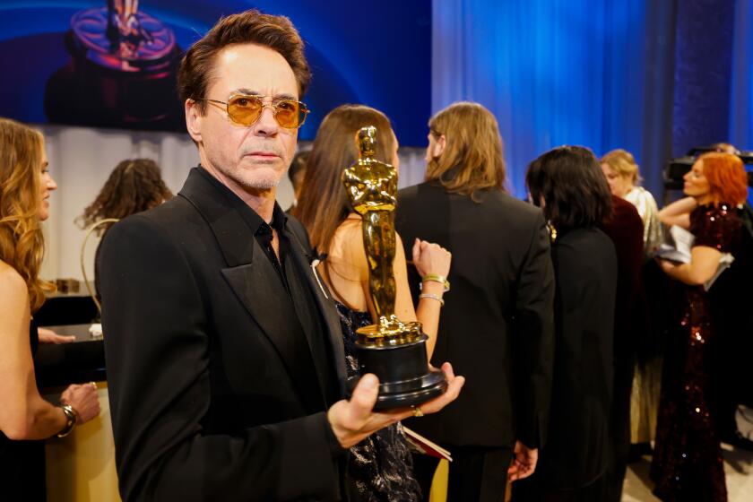 A man holds an Oscar statue.
