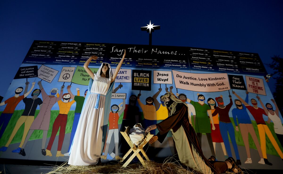 Claremont United Methodist Church's Nativity scene shows Mary, Joseph and baby Jesus in front of people wearing masks