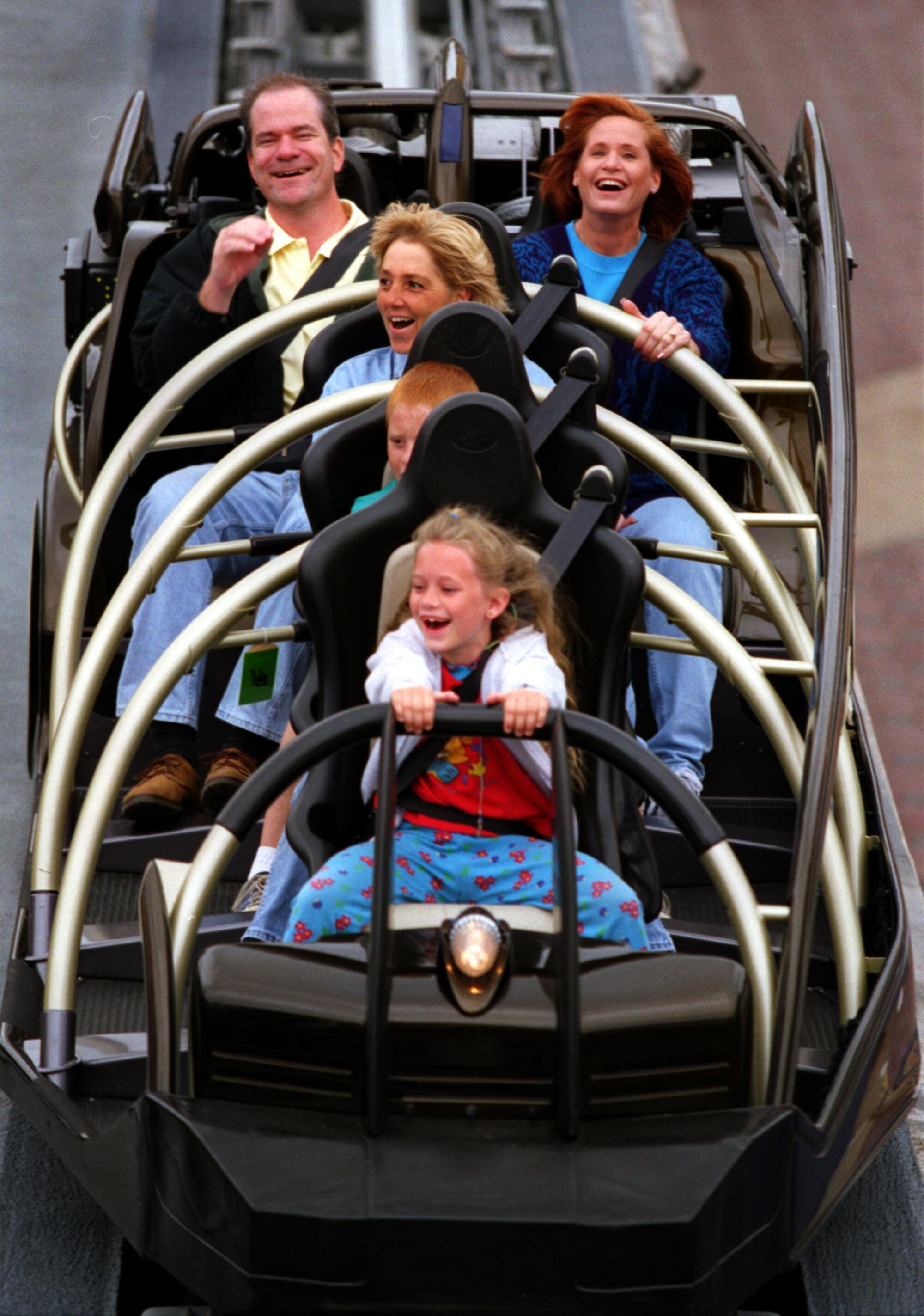A group of people riding a rocket-themed ride at Disneyland.