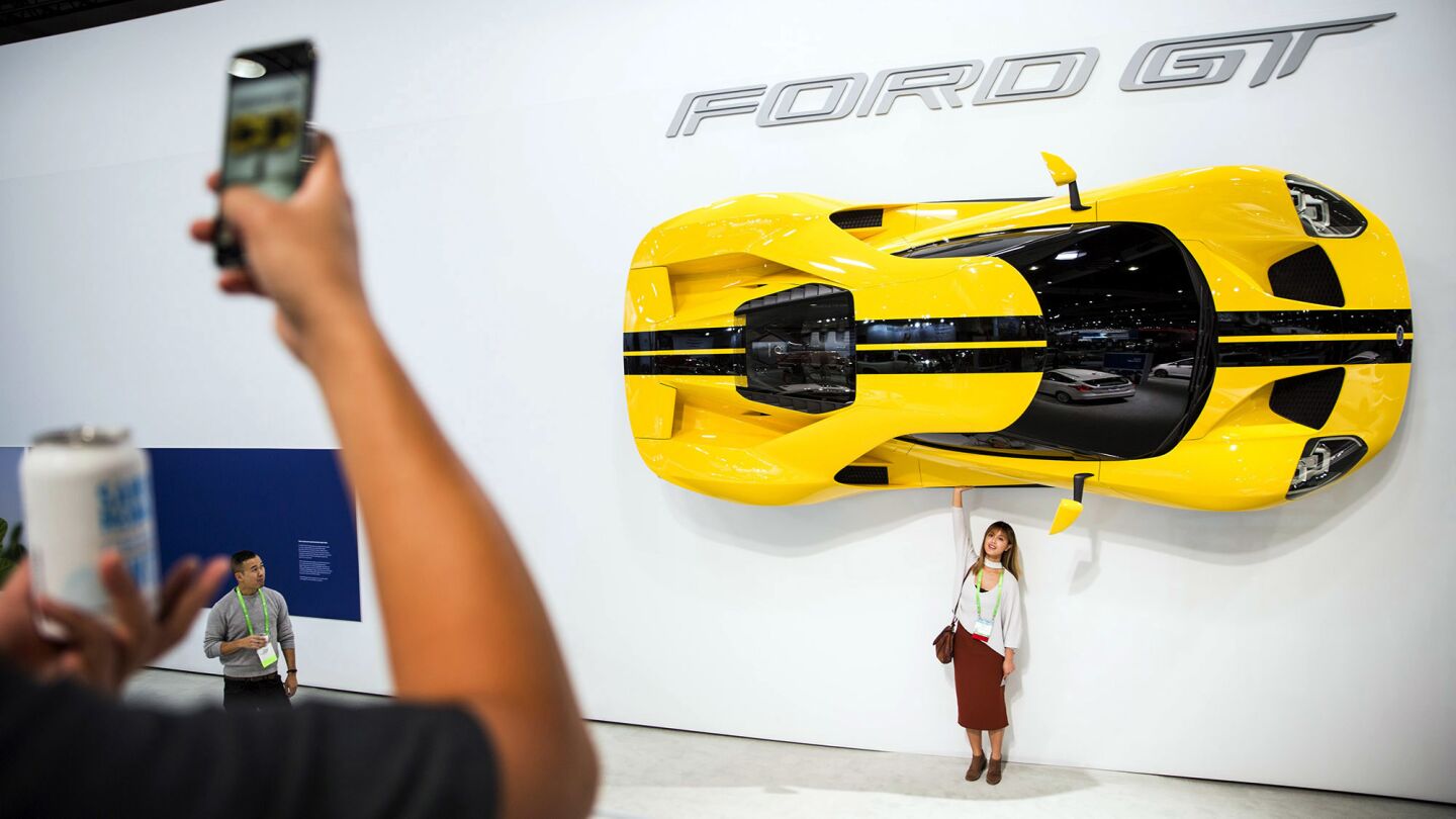 Sarah Gao poses for a picture beneath a Ford GT.