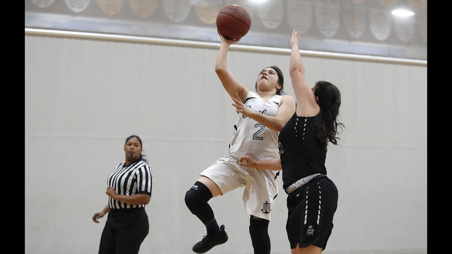 Newport Harbor's Lexi Alvarez goes up for a shot against Costa Mesa's Samantha Filner during a game at the Hawk Holiday Classic at Ocean View High School on Friday, December 8.