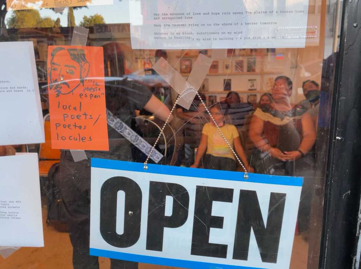 A sign outside a poetry reading that shows it's open