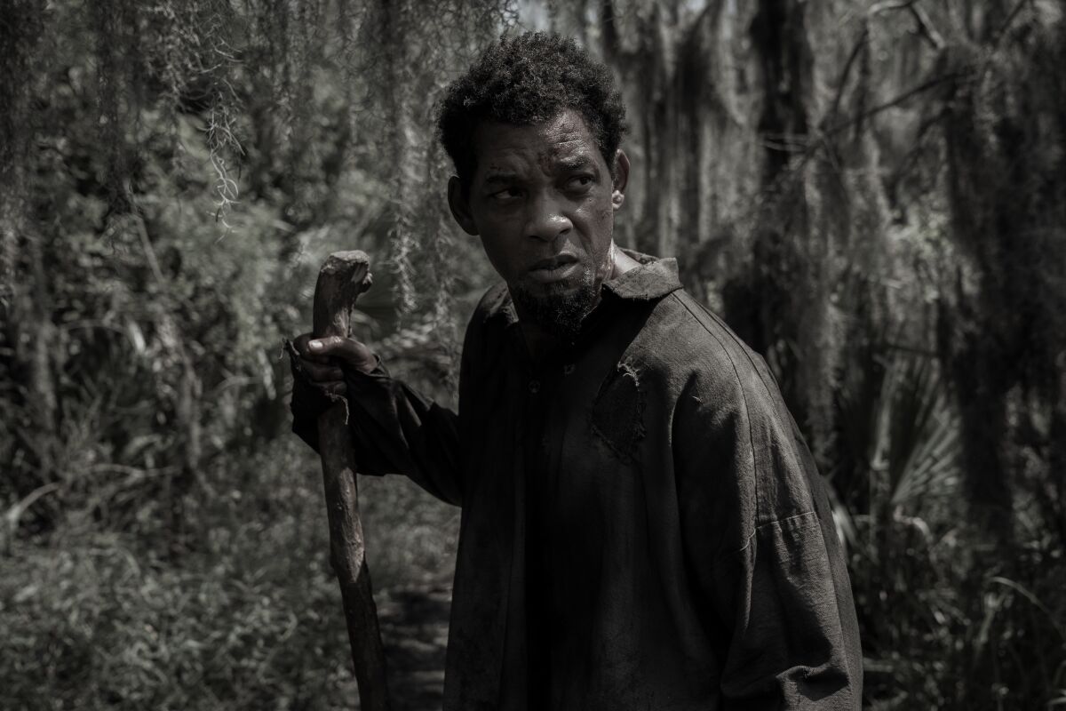 A bedraggled man escaping slavery walks in a swamp.