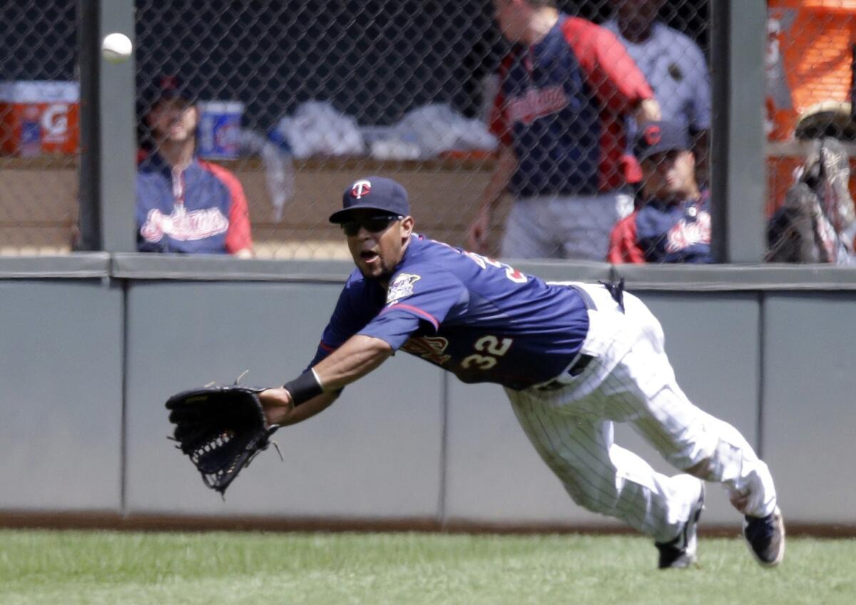 Minnesota Twins outfielder Aaron Hicks dives to make a catch against the Cleveland Indians on Sunday. The former Long Beach Wilson High star is working hard to make his major league dreams a reality.