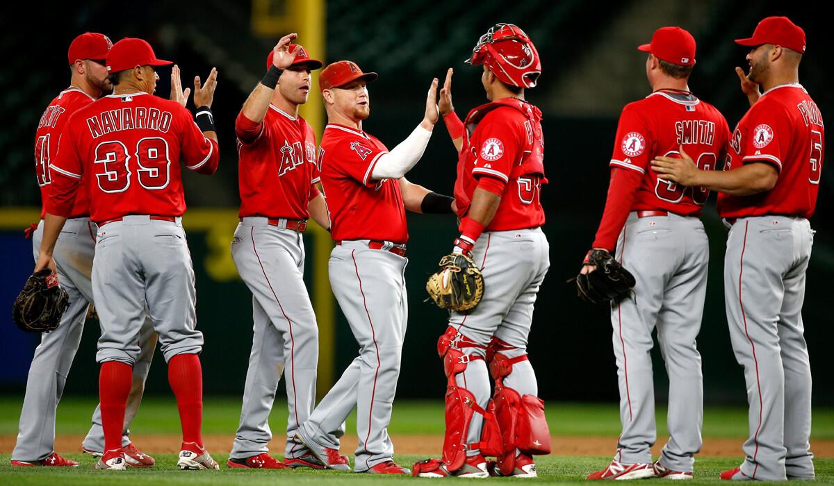 The Angels celebrate after defeating the Seattle Mariners, 4-3, on Tuesday.