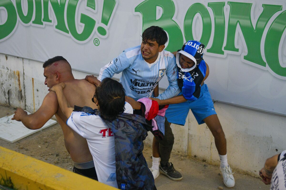 Fans clash during a Liga MX match between Querétaro and Atlas at Corregidora Stadium in Querétaro, Mexico, Saturday.
