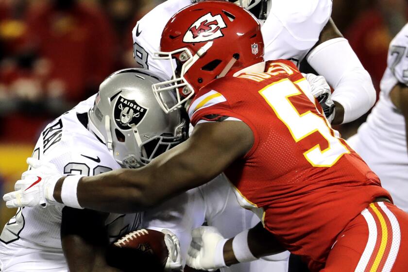 Chiefs linebacker Justin Houston (50) brings down Raiders running back Latavius Murray during the first half of their game Dec. 8.